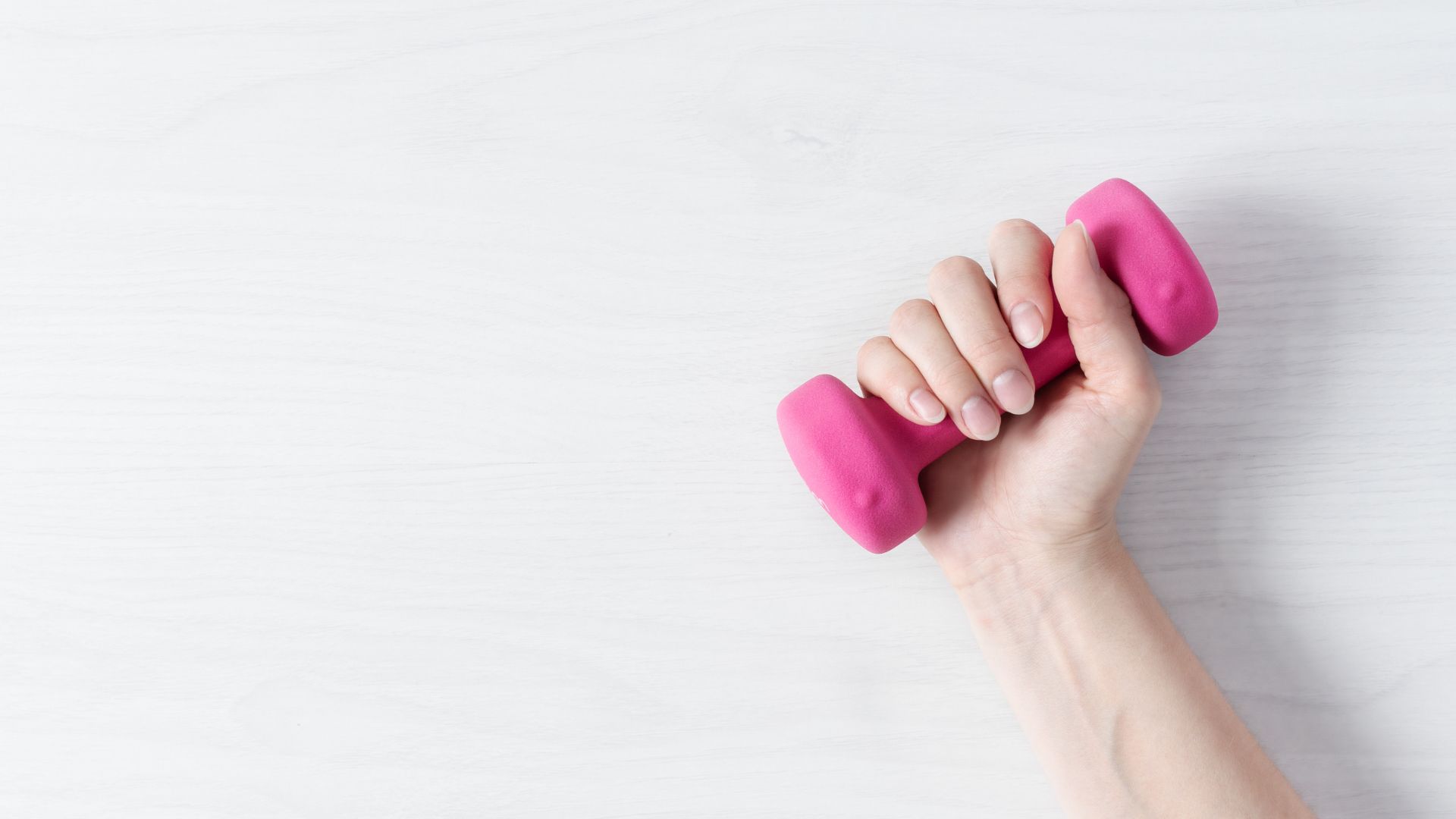 Vrouw van 40+ traint met roze gewicht – beweging en spieropbouw bij ketogeen dieet