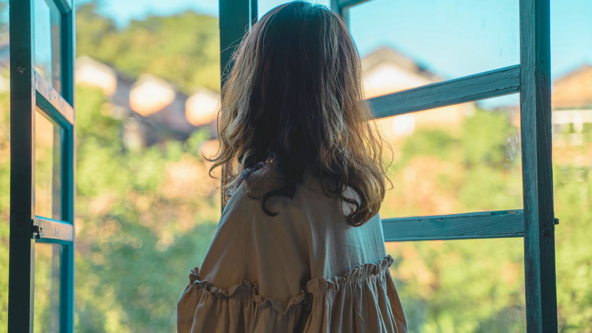 Vrouw die kalm uit het raam kijkt