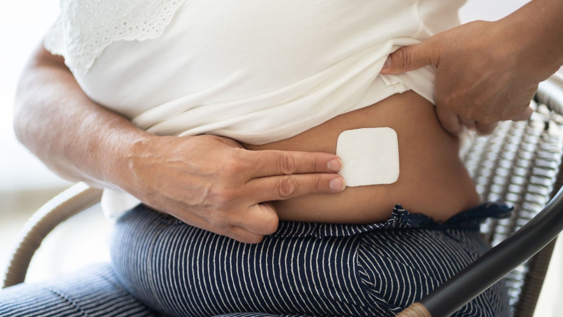 vrouw die HST pleister plakt op huid